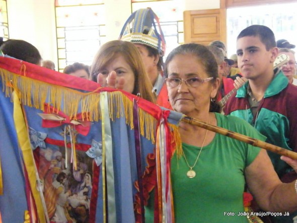 Sebastiana leva a bandeira durante a entrada na capela.