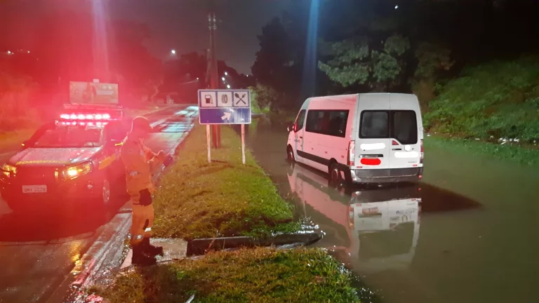 Chuva provoca alagamento em avenida e van fica presa